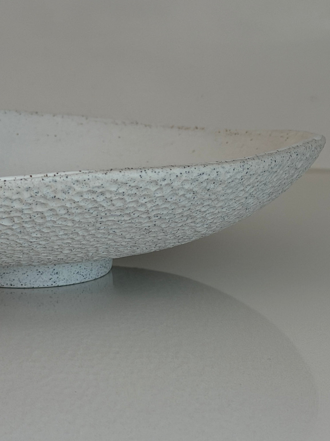 Side detail showing the raised foot and textured exterior